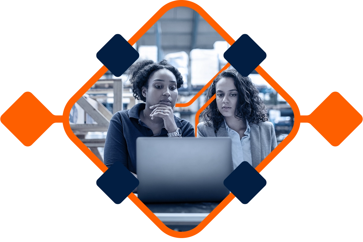 Female worker with supervisor working on laptop. Factory workers working together.